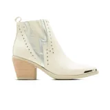 Bota corta de vestir Korium Inari color blanco marfil con detalles plateados en forma de rayo, tachas decorativas, puntera metálica y taco cuadrado de madera.
