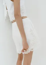 Short blanco de tiro regular, corte recto y largo corto, confeccionado en mezcla de algodón y lino, con detalle de bordado en el bajo.