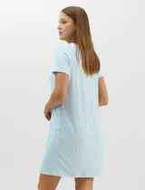 Camisón corto de corte evasé celeste con estampado geométrico, mangas cortas y amplio escote redondo. Presenta detalle de puntilla calada en el contorno del cuello con pequeño moño decorativo en el centro y fruncidos frontales.