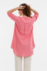 Camisa blanca de viscosa de corte oversize, con cuello camisero, cierre frontal de botones y bolsillo ojal en el pecho.