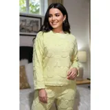 Conjunto de pijama de dos piezas confeccionado en plush suave con textura de ochos. Incluye una remera de manga larga con cuello redondo y un pantalón de corte recto con cintura elástica.