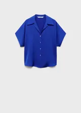 Camisa azul eléctrico de tejido satinado, manga corta, cuello camisero y cierre frontal con botones. Corte regular.