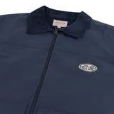 Campera azul marino con cuello de pana, cierre frontal, puños abotonados y elástico en la cintura. Tiene un parche ovalado con el logo de la marca en el pecho.