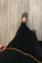 Falda larga negra tejida con cintura elastizada ajustable con cordón.