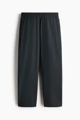Pantalón deportivo de corte estándar y piernas rectas, confeccionado en tejido funcional ripstop con tecnología DryMove para absorción de sudor. Presenta cintura elástica con cordón oculto, bolsillos laterales con cierre y detalles perforados en los laterales de las piernas.