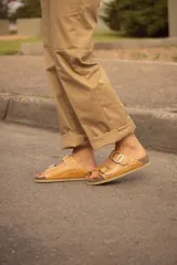 Sandalias de cuero color ocre con estampado croco, doble tira con hebillas metálicas ajustables y plantilla anatómica.