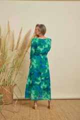 Vestido midi con estampado abstracto en tonos verdes y azules, cuello redondo, mangas tres cuartos y lazo ajustable en la cintura.