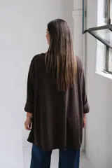 Remera de algodón color chocolate, de corte holgado y diseño oversize, con cuello redondo y mangas tres cuartos con terminación desflecada.