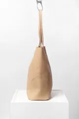 Bolso tote de cuero marrón con costuras a la vista y doble bolsillo interior, uno con cierre. Cierra con broche imán.