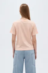 Remera de algodón de manga corta, color blanco, con cuello redondo y estampado frontal ilustrado con una mujer de perfil.