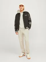 Hoodie color crema de manga larga con capucha, bolsillo canguro y calce holgado. Confeccionado con tejido de algodón y poliéster reciclado.