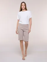 Bermuda elastizada de tiro alto estilo marinero, de silueta ajustada y entallada, con hilera lateral de botones metálicos decorativos.