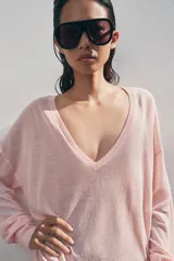 Jersey de punto fino negro con escote en V profundo y manga larga con puños ajustados.