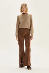 Sweater de punto color beige, con cuello redondo, manga larga y puños acanalados.