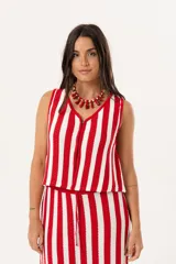 Chaleco tejido sin mangas con diseño de rayas verticales en color rojo y blanco. Presenta escote en V y cierre frontal con ganchitos ocultos.