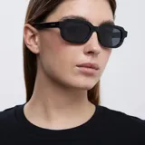 Lentes de sol negros con montura cuadrada de bordes redondeados.