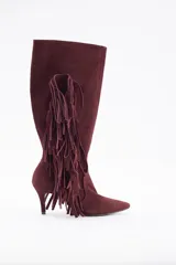 Bota de caña alta confeccionada en cuero vacuno color bordó, con diseño de flecos laterales y taco fino.