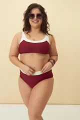 Conjunto de bikini bicolor en bordó y blanco, compuesto por un top deportivo de escote redondo y bombacha de tiro alto con detalle de banda blanca en la cintura.