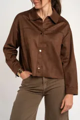 Sobrecamisa oversize de gamuza vegana marrón, con cuello camisero, mangas largas y cierre frontal de botones metálicos.