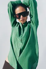 Camisa de viscosa ZW Collection con estampado de rayas verdes, cuello redondo mao, manga larga con puños anchos, pechera frontal y bajo asimétrico redondeado con cierre de botones.