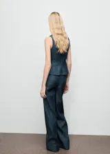 Pantalón de tiro alto con diseño wide leg, confeccionado en tejido de algodón y lyocell estilo denim. Presenta costuras verticales decorativas, bolsillos laterales y cierre oculto con botón, gancho y cremallera.