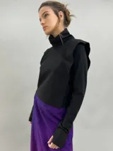 Buzo de jersey de lana color negro, con cuello elevado, hombreras estructuradas y mangas largas con puños con ojal para el pulgar.