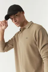 Polo de manga larga color beige con textura, fit regular, logo estampado y puños.