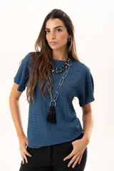 Blusa de silueta relajada y cuello redondo, confeccionada en tela liviana con textura. Presenta mangas cortas y una caída suelta.