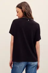 Remera de lino y viscosa color blanco, de corte holgado, manga corta y escote en V con detalle de aplicación brillante.
