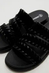 Sandalias planas color negro con tres tiras anchas adornadas con costuras cruzadas en el borde.