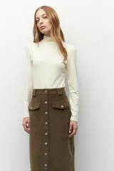Polera de cuello alto y manga larga, confeccionada en tejido suave y elástico, con un ajuste al cuerpo.
