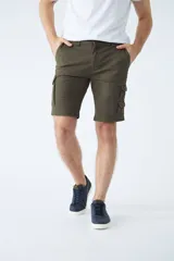 Bermuda cargo color verde militar, con bolsillos laterales tipo cargo, cierre de cremallera y botón, y pasacintos.
