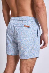 Short de baño con estampado botánico en tonos tierra, rosados y verdes. Presenta cintura elástica con cordón ajustable y un pequeño parche con logo en el ruedo.