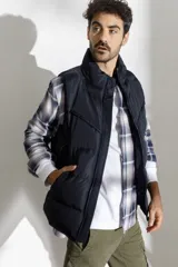 Chaleco acolchado azul marino con cierre frontal y cuello alto.