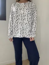 Pijama de algodón compuesto por una remera manga larga con estampa floral, cuello redondo y cierre frontal de botones, y un pantalón liso.