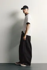 Pantalón barrel fit de mezclilla color verde militar, con efecto lavado, cinco bolsillos, cierre frontal con cremallera y botón, y detalle de pinzas en las rodillas.