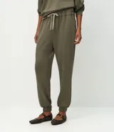 Pantalón tipo jogger de corte holgado con cintura elástica y cordón bicolor ajustable. Presenta puños elásticos en los tobillos y bolsillos laterales.