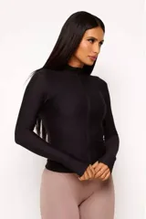 Campera negra de poliamida y elastano con textura tipo panal, cierre frontal completo, cuello alto y mangas largas con orificios para los pulgares.