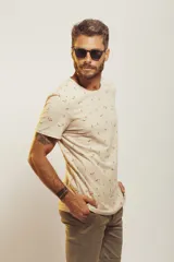 Remera de cuello redondo y manga corta, color beige con estampado de pequeños motivos playeros.