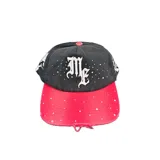 Gorra con visera curva roja y cuerpo negro de efecto desgastado, con bordado frontal estilo gótico y aplicación de strass.