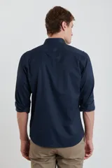 Camisa azul marino de manga larga con cuello abotonado y bolsillo en el pecho.