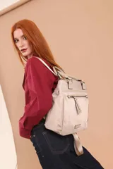 Cartera mochila de diseño versátil, color rosado, confeccionada en material sintético impermeable. Cuenta con doble asa superior, correas ajustables para usar como mochila, compartimento principal con cierre y bolsillo frontal con cierre decorado con tirador largo.