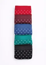 Pack de cinco bombachas tipo cola less confeccionadas en microfibra sin costuras, con diseño estampado de lunares blancos sobre fondo de colores variados: rojo, bordó, azul, verde y negro.