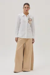 Camisa blanca de algodón y lino con bordado de flor en el frente.