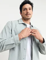 Sobrecamisa verde de manga larga con cuello camisero, cierre frontal con botones y bolsillo de parche en el pecho.