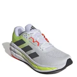 Championes de running Adidas Questar 3, con diseño técnico en malla transpirable color blanco, detalles en verde lima y franjas laterales en gris oscuro. Cuenta con entresuela amortiguada y suela de goma resistente.