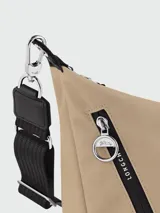 Bolso tipo crossbody de la línea Le Pliage Energy de Longchamp, en color beige. Presenta una correa ajustable y extraíble, cierre frontal con cremallera decorado con una cinta con el logo de la marca y un parche con el icónico caballo de Longchamp.