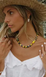 Collar de cerámica con cuentas de colores y un dije en forma de pez amarillo.
