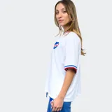 Remera de fútbol Umbro del Club Nacional de Football para mujer. Diseño azul con detalles tricolor en cuello y mangas. Incluye logo de Umbro y escudo del club en el frente.