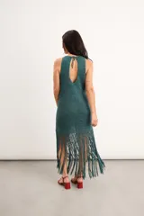 Vestido midi de crochet bordó con destellos de lurex, de cuello redondo y sin mangas, con falda terminada en largos flecos trenzados a mano.